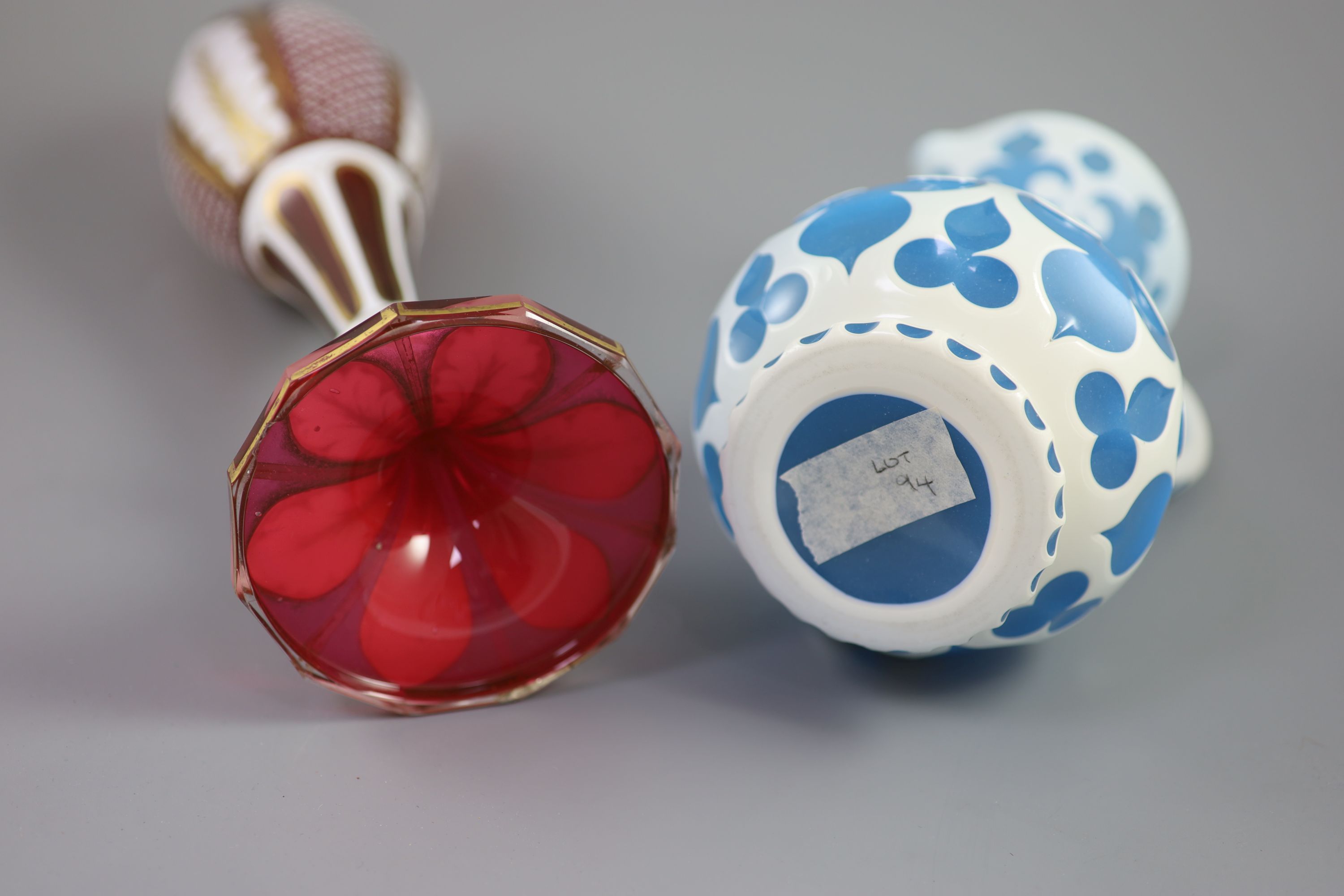 A Bohemian blue and white overlaid glass jug and a similar ruby and white overlaid glass vase, tallest 35cm